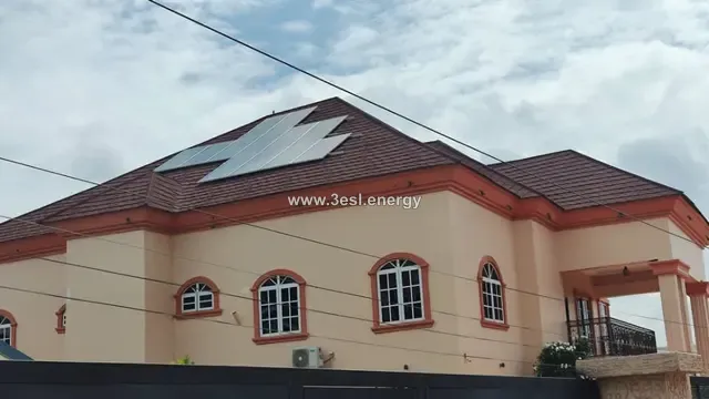 A large private house with a solar array covering the pitched section of its roof.