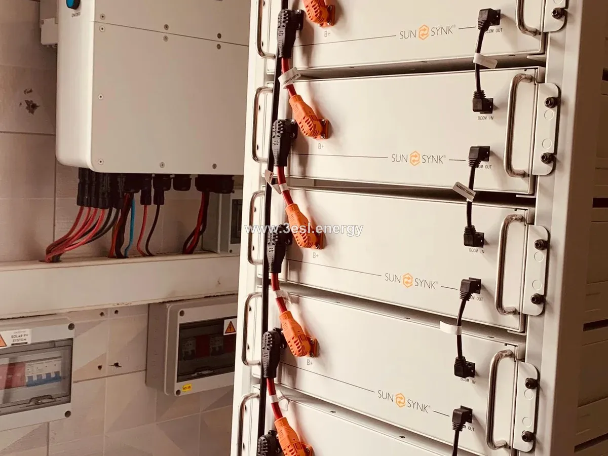 A Sunsynk hybrid inverter beside a rack of Sunsynk battery modules.